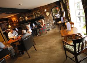 a group of people sitting at tables in a restaurant at Rose And Crown in Porthcawl