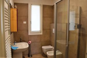 a bathroom with a toilet and a sink and a shower at Villetta Pima in Garda +28 photos