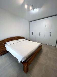 a bedroom with a large bed and white cabinets at Villetta Pima in Garda
