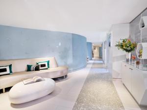 a living room with a couch and a ottoman at Le Meurice – Dorchester Collection in Paris