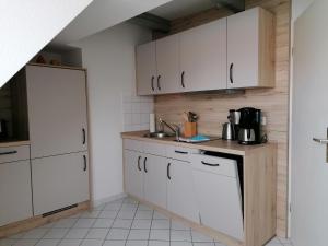 a kitchen with white cabinets and a sink at Ferienwohnung Neuer Weg 15 in Quedlinburg
