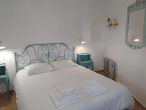 1 dormitorio con 1 cama blanca y 2 toallas en Casa con piscina cerca de Sevilla, en Carrión de los Céspedes
