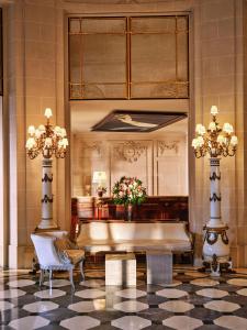 a lobby with a large mirror and a tub at Le Meurice – Dorchester Collection in Paris