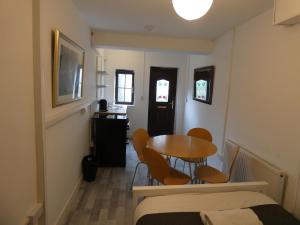 een kleine kamer met een tafel en stoelen en een bed bij Bridge Street Studio Room in Merthyr Tydfil