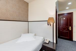 een hotelkamer met een bed en een telefoon bij Borjomi Palace Health & Spa Center in Borjomi