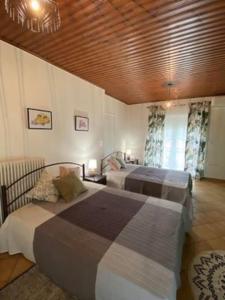 1 dormitorio con 2 camas y techo de madera en Laki's House Οροφοδιαμέρισμα με σοφίτα, en Thermo