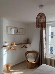 a bedroom with a basket chair and a window at Appartement Les Corsaires in Granville