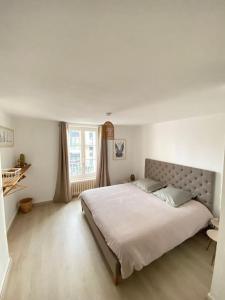 een slaapkamer met een groot bed en een raam bij Appartement Les Corsaires in Granville