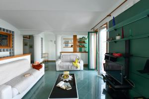 a living room with a white couch and a green wall at La casa del Conte - Amalfi Coast in Amalfi