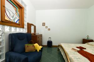 een slaapkamer met een blauwe stoel en een bed bij La casa del Conte - Amalfi Coast in Amalfi