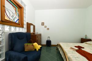 a bedroom with a blue chair and a bed at La casa del Conte - Amalfi Coast in Amalfi