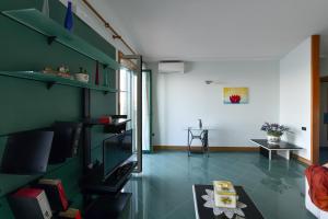 a living room with a green wall and a television at La casa del Conte - Amalfi Coast in Amalfi