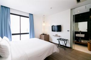 a bedroom with a white bed and a large window at Uno Express (SHA) in Bangkok