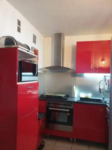 a kitchen with red cabinets and a stove at Le Queirélé in Le Lavandou