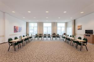 Holiday Inn Express Nürnberg-Schwabach في شفاباخ: قاعة اجتماعات مع طاولات وكراسي وتلفزيون