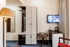 a hotel room with a desk and a table at Borjomi Palace Health & Spa Center in Borjomi