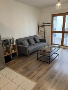 a living room with a couch and a glass table at Appartement 2 pièces ligne 1 in Montreuil