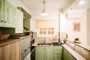 a kitchen with green cabinets and a sink at Melos House in Zakynthos Town