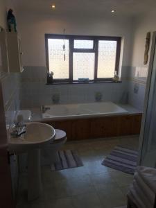 a bathroom with a tub and a toilet and a sink at Brook beach retreat, Porthtowan, Cornwall in Porthtowan