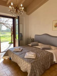 a bedroom with a large bed and a chandelier at Villa Vacasio Bio-Eco in Pitigliano