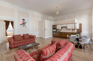 a living room with two red couches and a table at York Place Apartments by Destination Edinburgh in Edinburgh