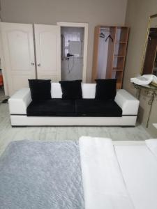 - un canapé blanc avec des oreillers noirs dans le salon dans l'établissement Masal Otel, à Kocaeli