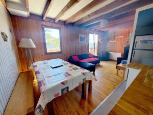 een kleine woonkamer met een tafel en een bank bij Chalet Vue sous cet Angles in Les Angles
