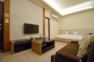 a hotel room with a bed and a television at GJia Taitung B&B in Taitung City
