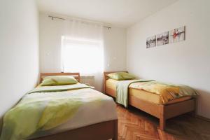 two twin beds in a room with a window at Pri Neji in Postojna