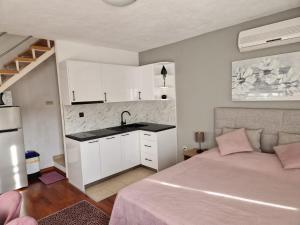 1 dormitorio con 1 cama y lavamanos y cocina en Apartments Ozrenka, en Tučepi