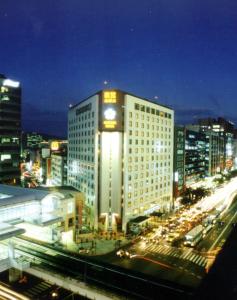 a tall building with a clock on it in a city at Brother Hotel in Taipei