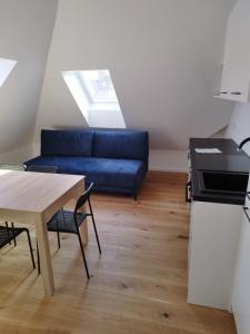 a living room with a blue couch and a table at Krems am Campus in Krems an der Donau