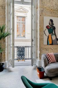 a living room with an open door and a couch at Edgar Suites Louvre - Richelieu in Paris