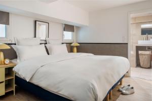 a bedroom with a large white bed with white pillows at Edgar Suites Louvre - Richelieu in Paris