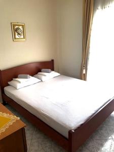 a bed with white sheets and pillows in a bedroom at New elegant apartment in Kallithea Xalkidiki in Kallithea Halkidikis