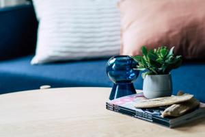 a table with a clock and a vase on a book at Sanierter Altbau, 2 Zimmer, 24-7 Check-in in Kiel +4 photos