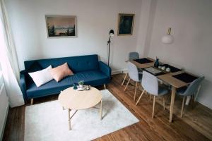uma sala de estar com um sofá azul e uma mesa em Sanierter Altbau, 2 Zimmer, 24-7 Check-in em Kiel
