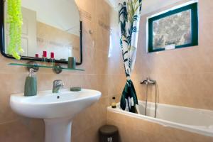 La salle de bains est pourvue d'un lavabo, d'un miroir et d'une baignoire. dans l'établissement Helen by the River 3, à Alykes Potamou