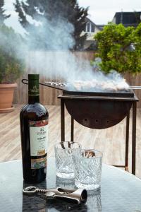 una bottiglia di vino e bicchieri su un tavolo con griglia di Terrace View a Tbilisi City