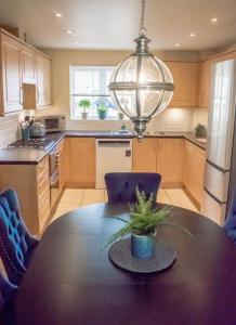 a kitchen with a table with a potted plant on it at Hibiscus House in Shilton