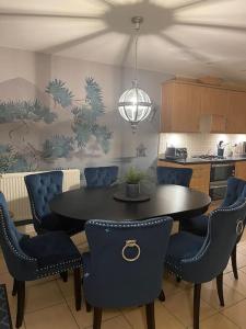 a dining room with a table and chairs in a kitchen at Hibiscus House in Shilton