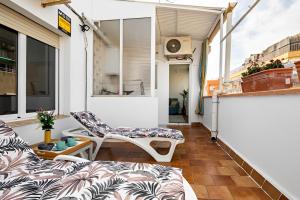 a balcony with a couch and a chair at Terrace Apartment in Sant Adria de Besos