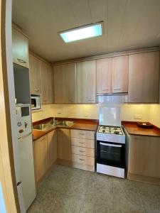 a kitchen with wooden cabinets and a stove top oven at Piso temporal Barcelona in Barcelona