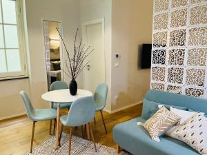 ein Wohnzimmer mit einem blauen Sofa, einem Tisch und Stühlen in der Unterkunft Rolli De Mar - Apartamento Boutique, elegante monolocale, Acquario di Genova, Genoa old town in Genua