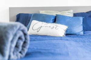 a blue bed with a pillow with the words get your guest at Luxury cosy apartment in Birmingham