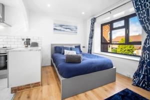 a bedroom with a blue bed in a kitchen at Luxury cosy apartment in Birmingham