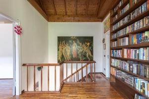 una escalera en una habitación con estanterías llenas de libros en Villa Monastero, en Arona