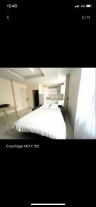 1 dormitorio con cama blanca y ventana en Cap d ail 2 pièces proches Monaco et plage en Saint-Antoine
