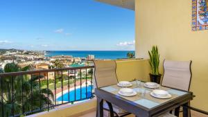 een balkon met een tafel en stoelen en de oceaan bij Seaview apt with pool by Costarentals - Ref 188 in La Cala de Mijas