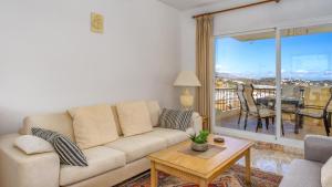 een woonkamer met een bank en een tafel bij Seaview apt with pool by Costarentals - Ref 188 in La Cala de Mijas